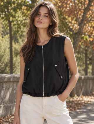 Gilet donna nero smanicato con zip argentata, tasche con patta e fondo arricciato