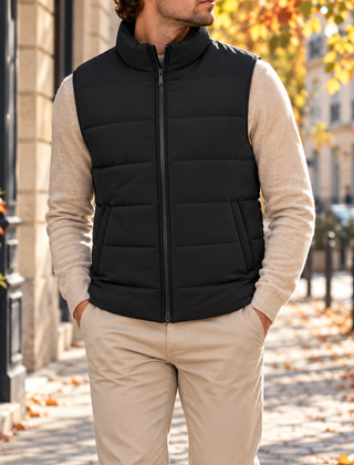Gilet nero imbottito indossato su maglione chiaro, zip frontale chiusa