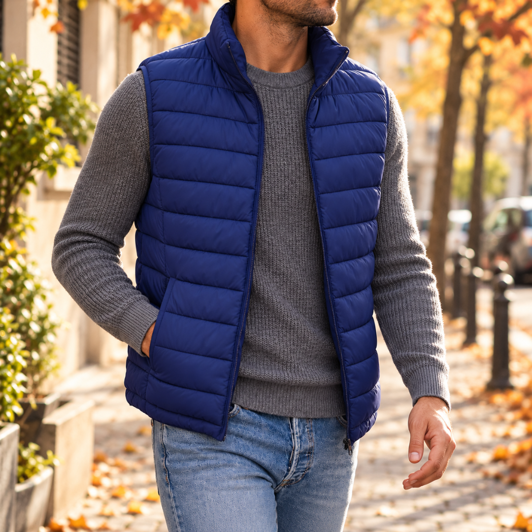 Gilet uomo blu senza maniche con zip aperta e collo alto, abbinato a pantaloni chiari