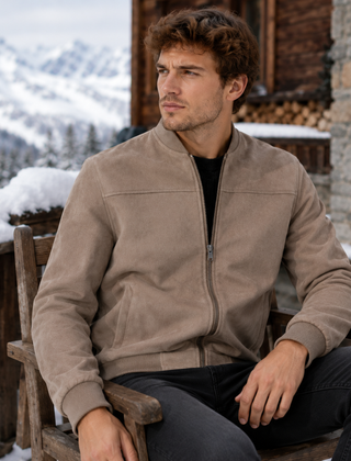 Bomber uomo beige effetto camoscio con zip aperta e collo a coste, indossato seduto