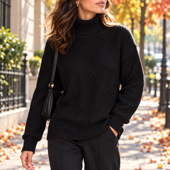 Maglione nero dolcevita con motivo a rombi e orlo arrotondato con spacchi