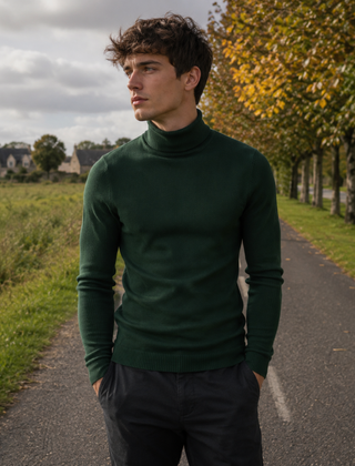 Maglione dolcevita verde scuro da uomo con collo alto lungo una strada alberata