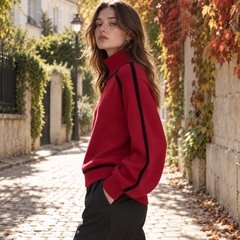 Vista laterale del maglione rosso a collo alto con profilo nero sulla manica