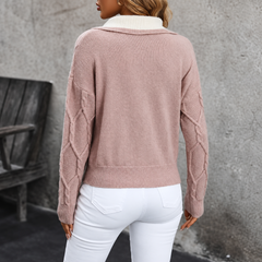 Vista posteriore del maglione rosa con fondo a coste e trecce sulle maniche