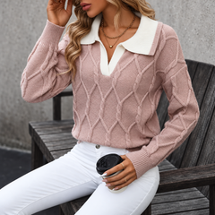 Donna seduta indossa maglione rosa con collo bianco e polsini a coste