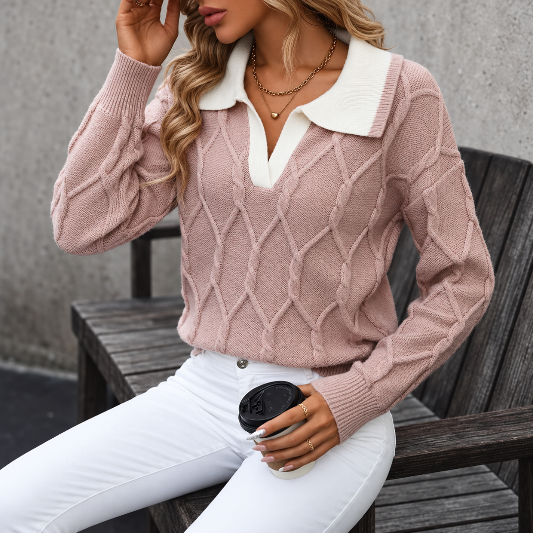 Donna seduta indossa maglione rosa con collo bianco e polsini a coste