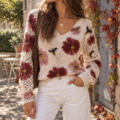 Dettaglio dello scollo a V del maglione donna a fiori rossi su fondo crema