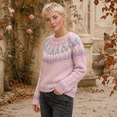 Maglione rosa a maniche lunghe con motivo geometrico pastello sul carré, posa di tre quarti