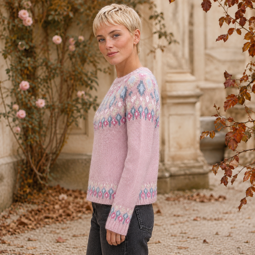 Vista laterale del maglione rosa con bordo inferiore jacquard e polsini decorati