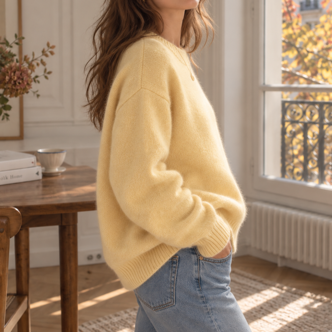 Vista laterale del maglione giallo oversize con maniche lunghe e polsini a coste