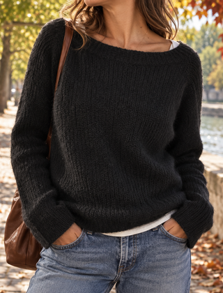 Maglione donna nero con scollo a barca e polsini a coste su pantaloni chiari