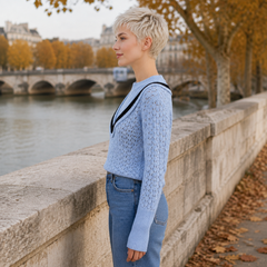 Maglione blu traforato visto di profilo con maniche lunghe e polsini a coste