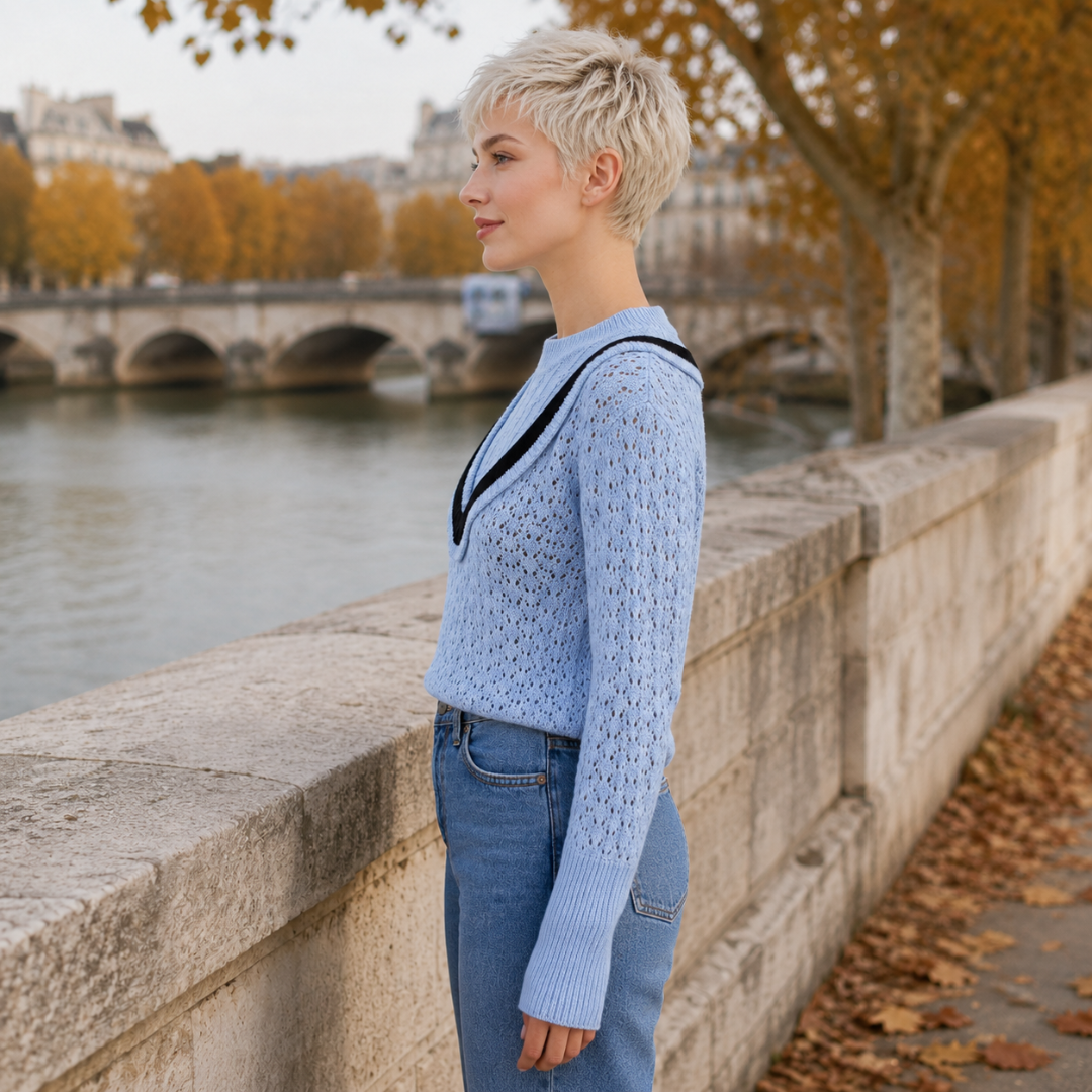 Maglione blu traforato visto di profilo con maniche lunghe e polsini a coste