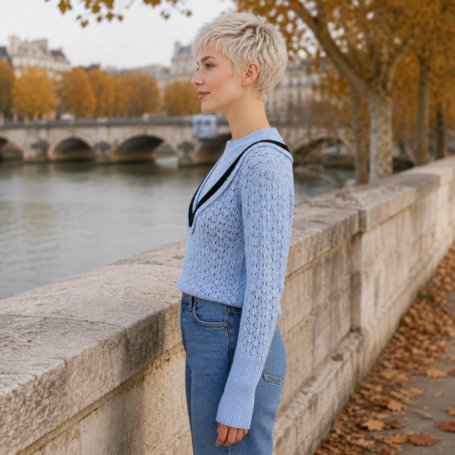 Maglione blu traforato visto di profilo con maniche lunghe e polsini a coste