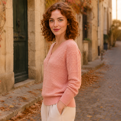 Vista laterale del maglione donna rosa con maniche lunghe e polsini a coste