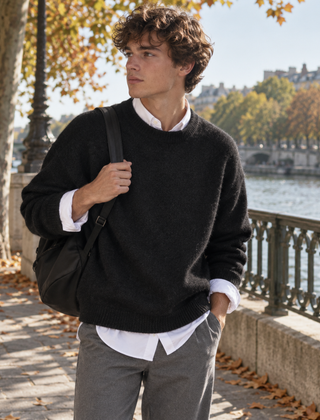Maglione uomo nero a girocollo con fondo a coste su pantaloni grigi