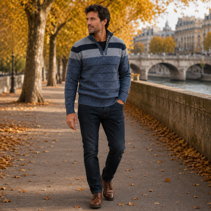 Uomo con maglione blu a righe con mezza zip, pantaloni scuri e stivaletti marroni