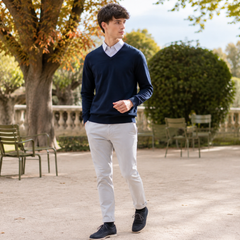Maglione uomo blu scuro con scollo a V, camicia a righe e pantaloni chiari
