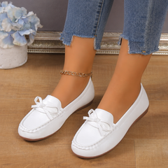 Dettaglio del fiocco sui mocassini bianchi da donna a calzata slip-on