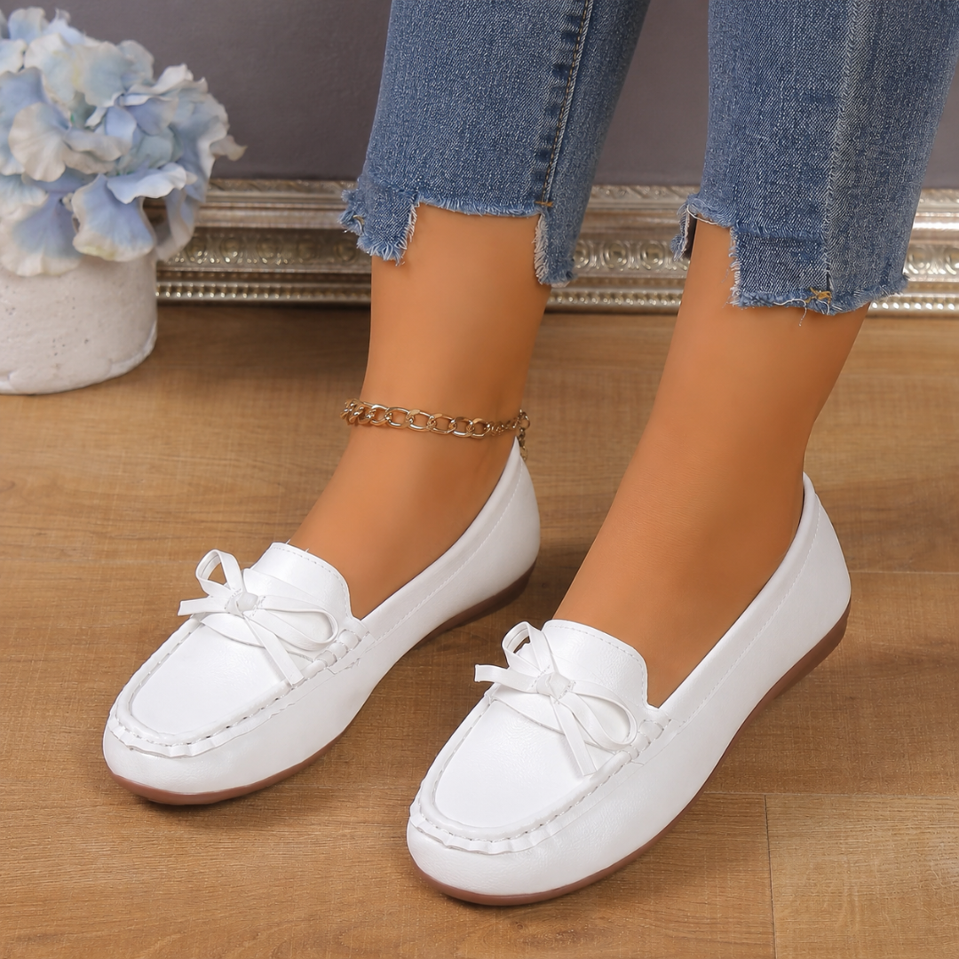 Dettaglio del fiocco sui mocassini bianchi da donna a calzata slip-on