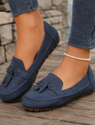 Mocassini donna blu navy con nappine e punta tonda su tavolato in legno