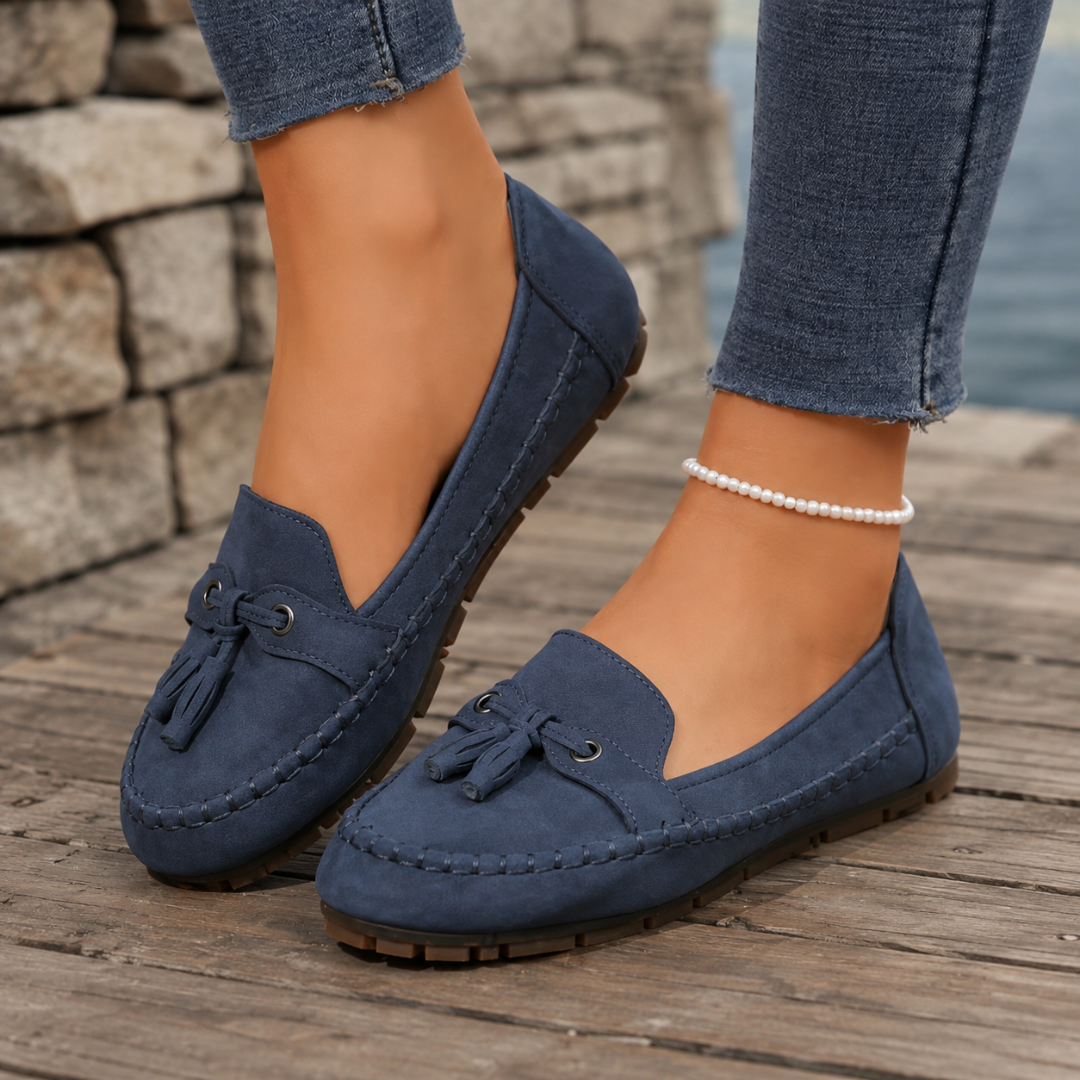 Mocassini donna blu navy con nappine e punta tonda su tavolato in legno