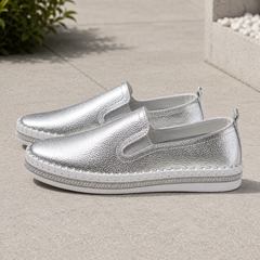 Paio di mocassini argento slip-on con cuciture a vista lungo il bordo