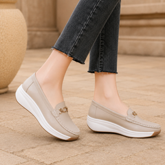 Mocassini beige visti di lato con zeppa alta e bordo marrone chiaro