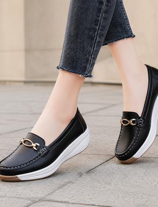 Mocassini donna neri slip-on con zeppa bianca e dettaglio dorato
