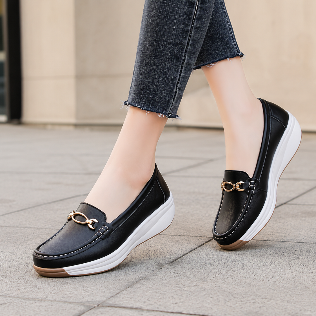 Mocassini donna neri slip-on con zeppa bianca e dettaglio dorato