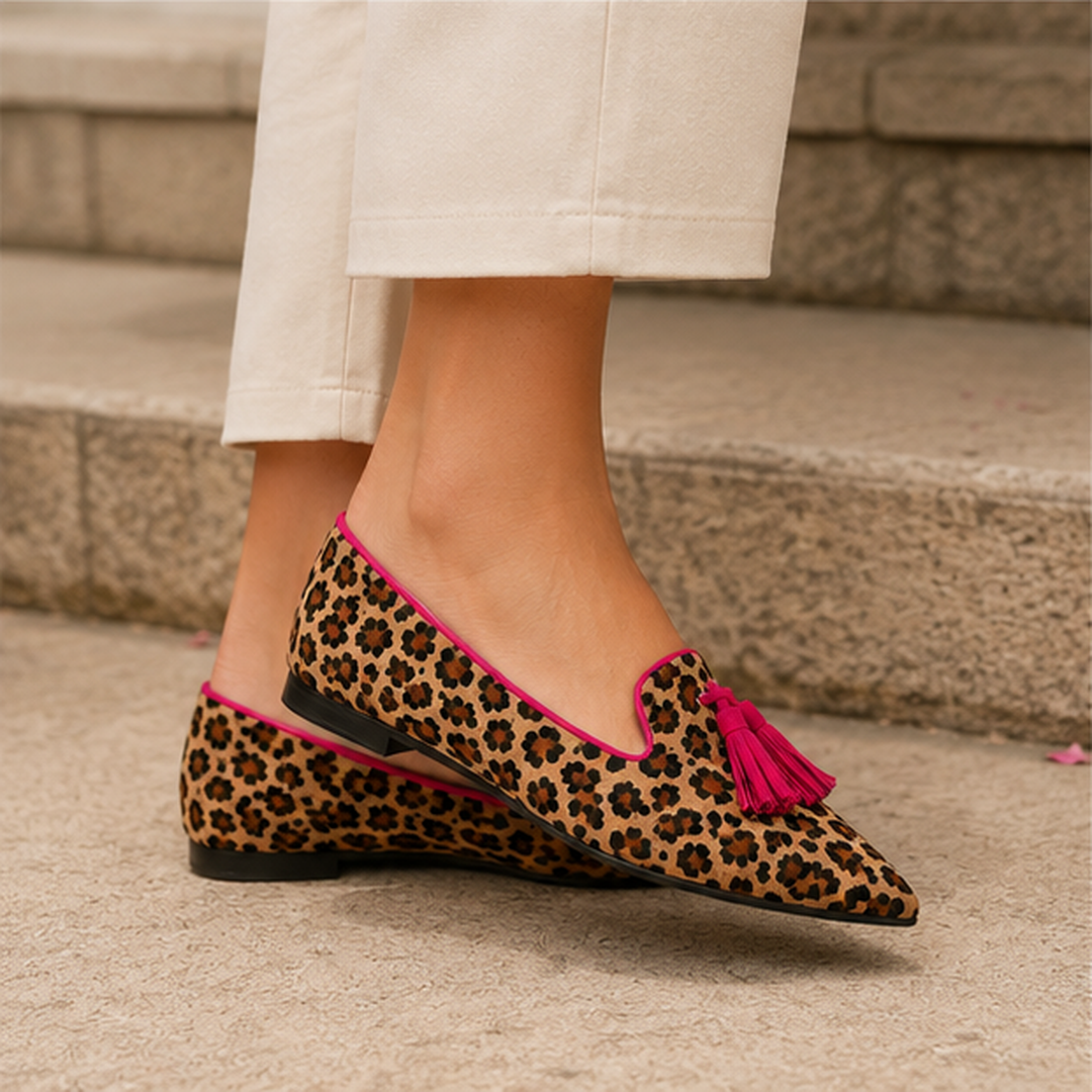 Mocassino leopardato di lato con nappina fucsia, suola piatta e tacco basso