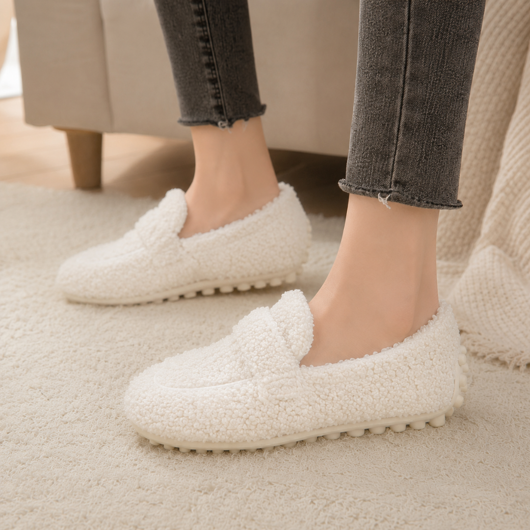Mocassini donna bianchi slip-on con suola dentellata in rilievo, indossati con pantaloni scuri