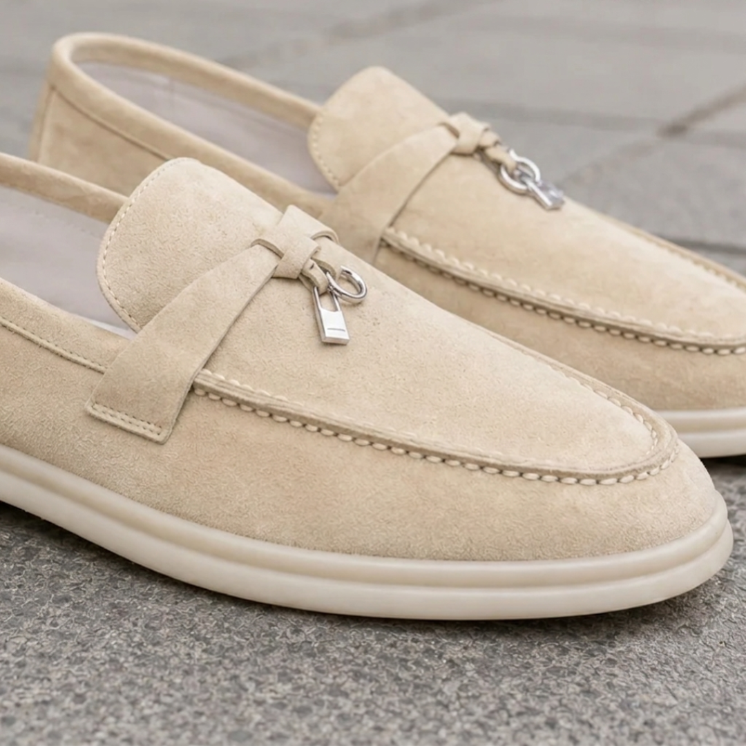 Dettaglio ravvicinato dei mocassini beige con cuciture a vista e ciondolo metallico