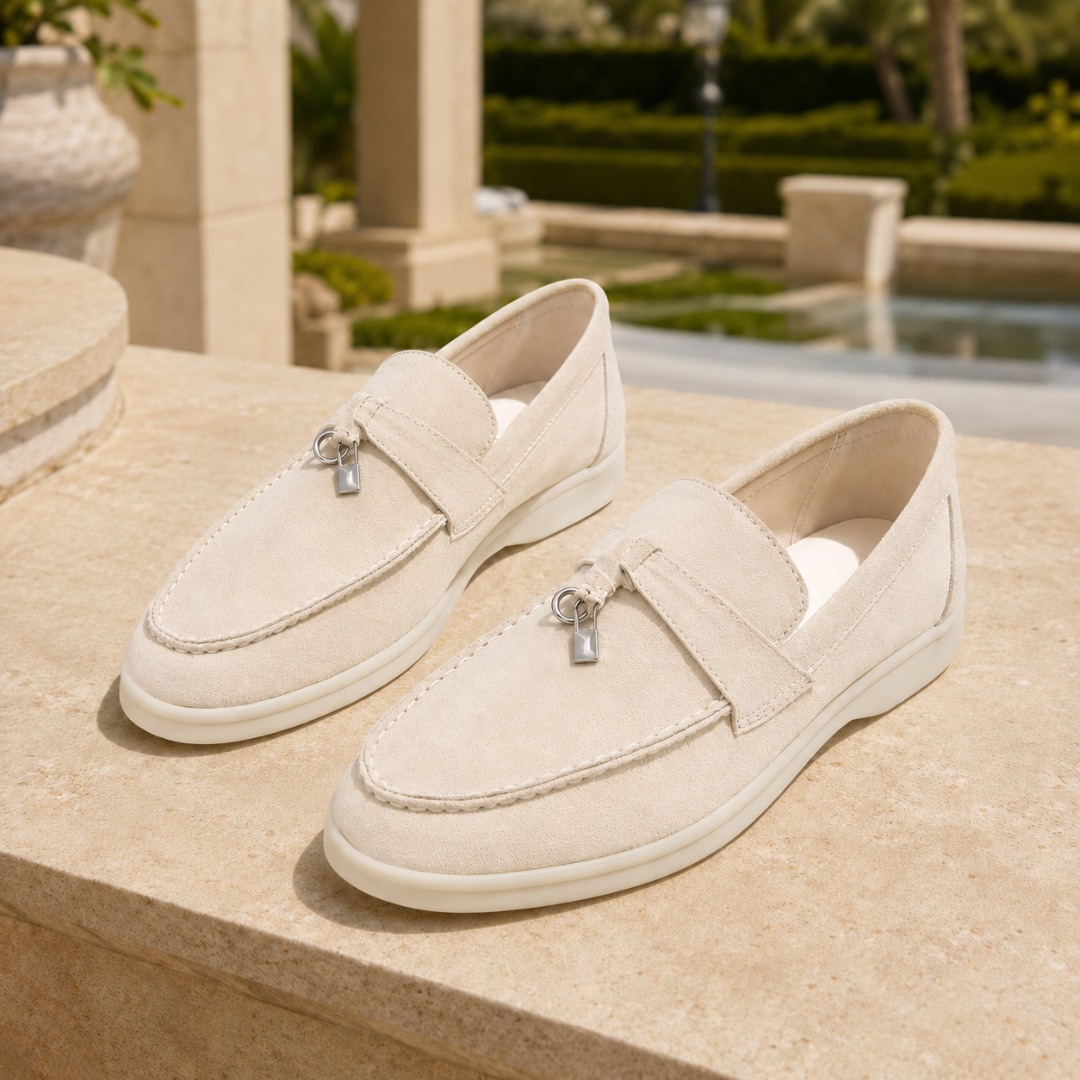 Mocassini crema slip on con punta arrotondata appoggiati su un muretto luminoso