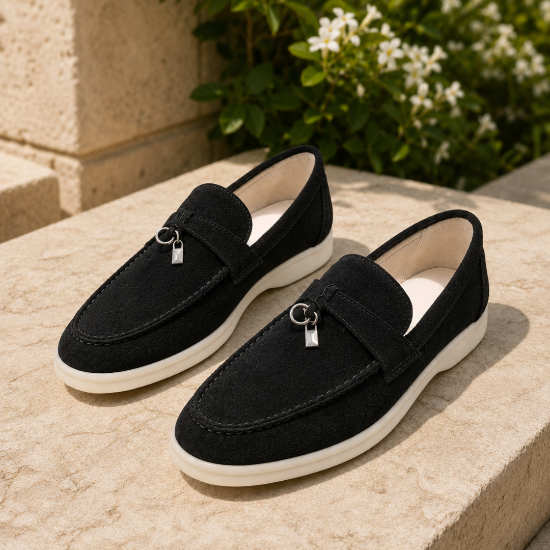 Mocassini neri slip on con pendente metallico e suola bianca tra il verde