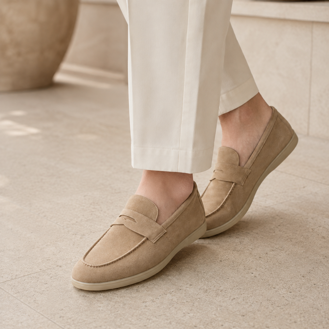 Mocassini beige da uomo indossati con pantaloni chiari, cuciture a vista sulla punta