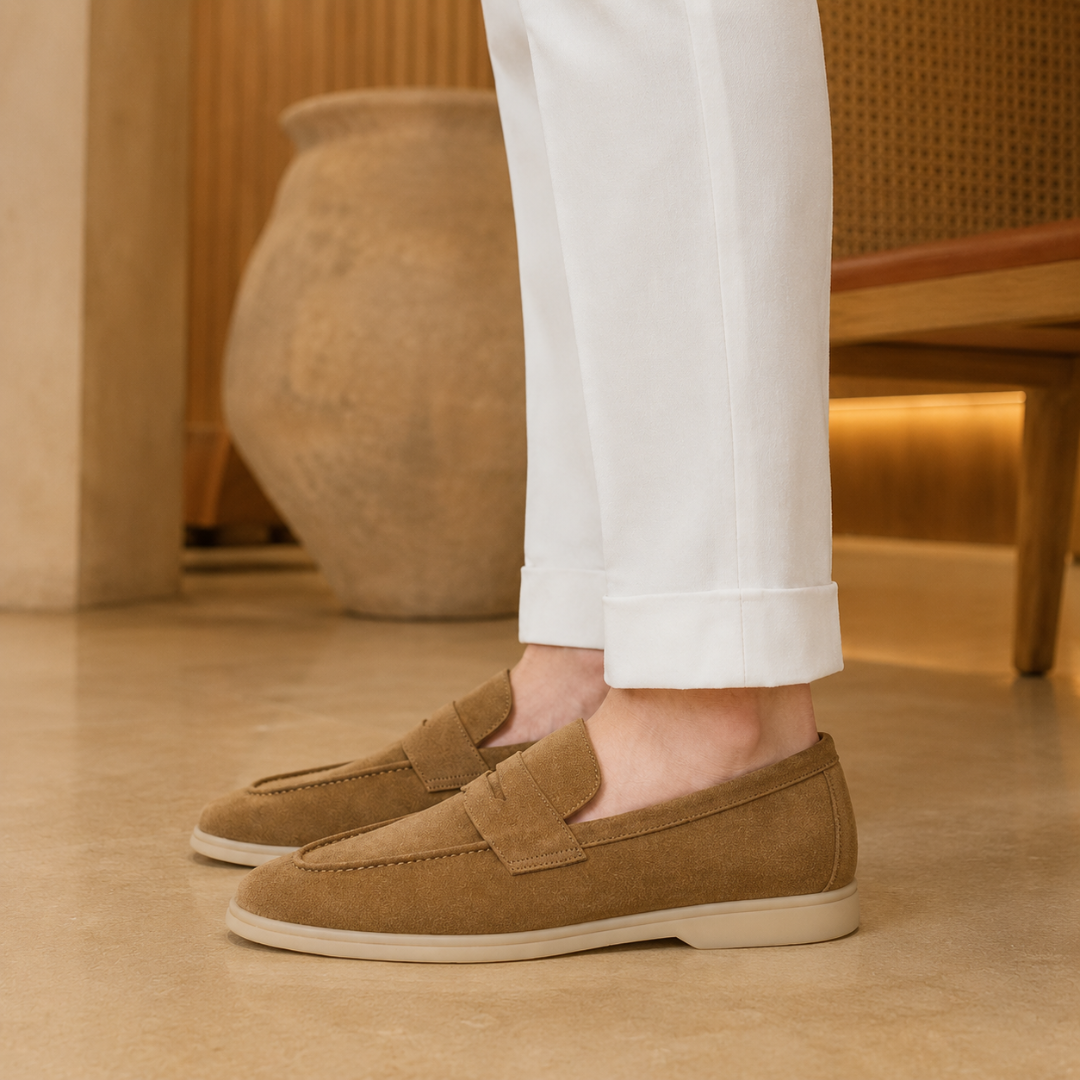 Mocassini marrone da uomo indossati con pantaloni bianchi risvoltati