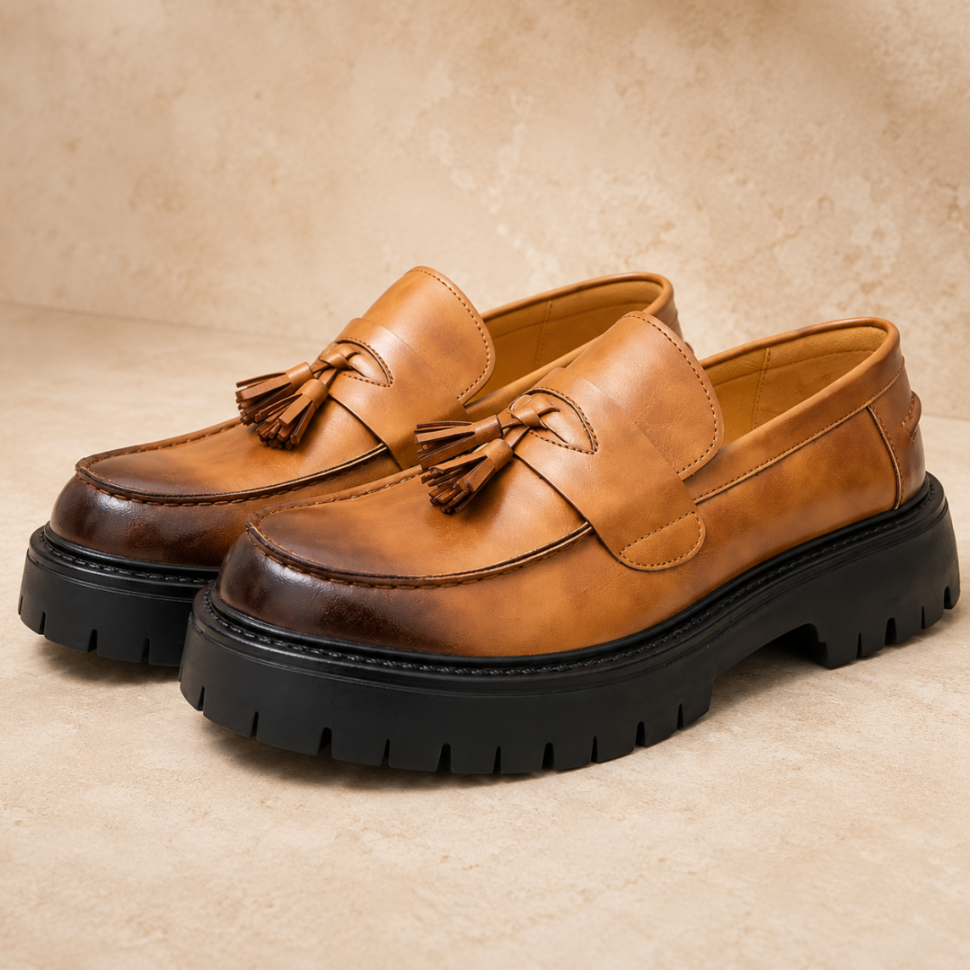 Mocassini cognac da uomo con fascia a sella e nappine, vista tre quarti frontale