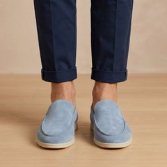 Mocassini uomo azzurri slip on visti frontalmente con suola chiara e pantalone blu