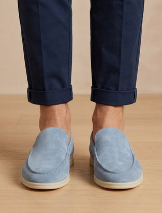 Mocassini uomo azzurri slip on visti frontalmente con suola chiara e pantalone blu