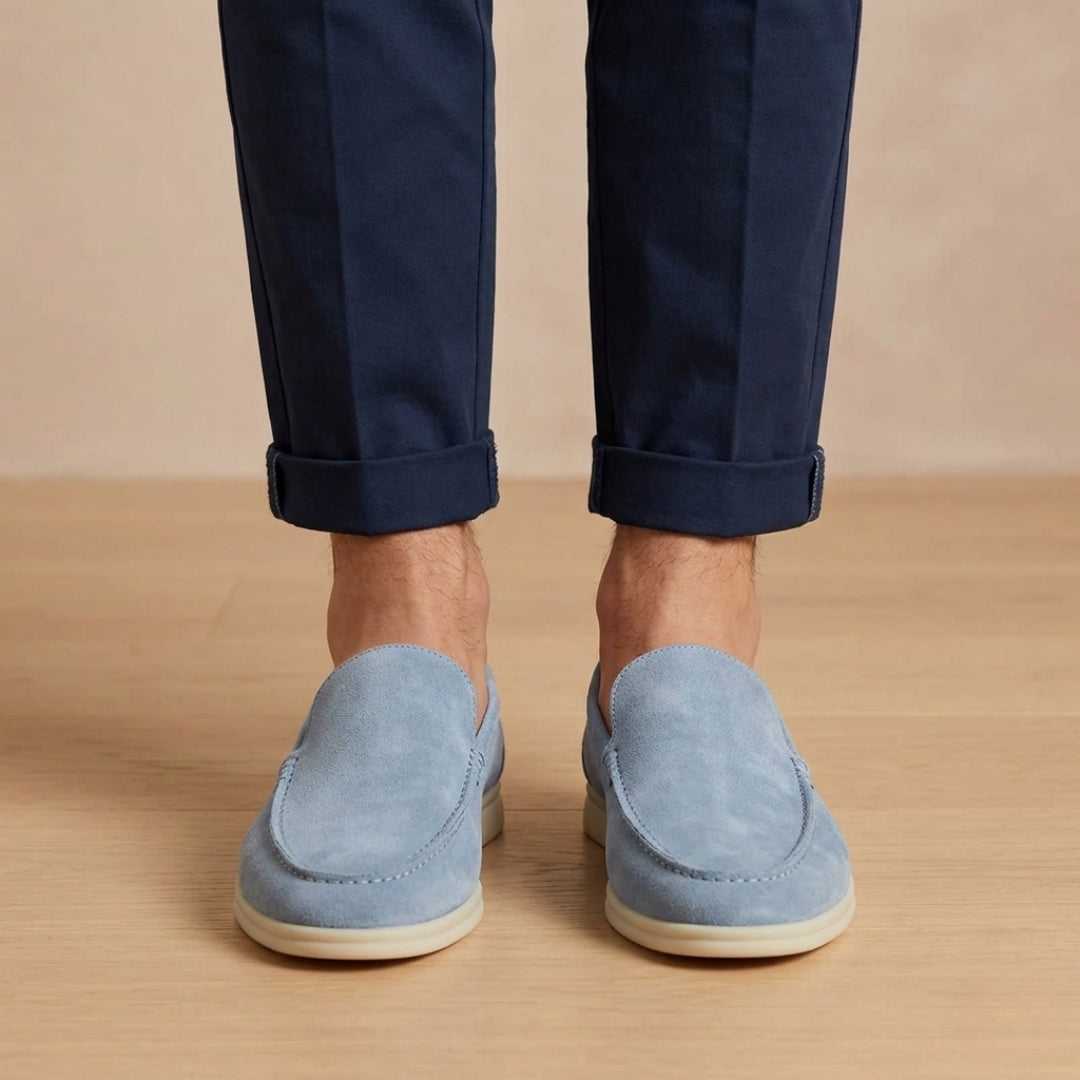 Mocassini uomo azzurri slip on visti frontalmente con suola chiara e pantalone blu