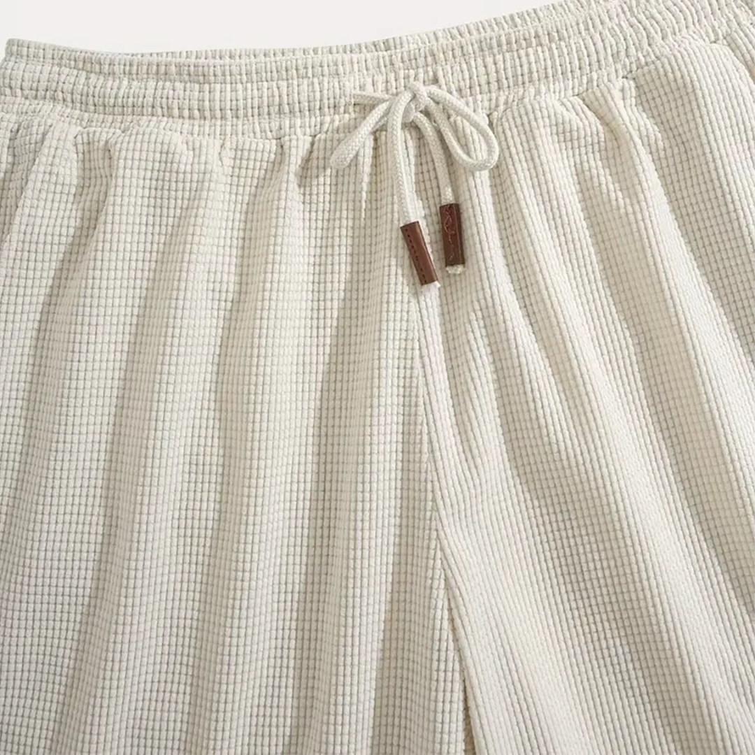 Dettaglio vita elastica dei pantaloncini beige con coulisse e puntali marroni