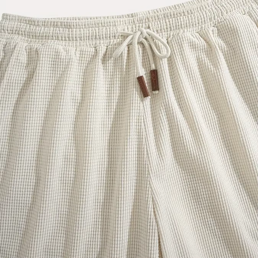 Dettaglio vita elastica dei pantaloncini beige con coulisse e puntali marroni