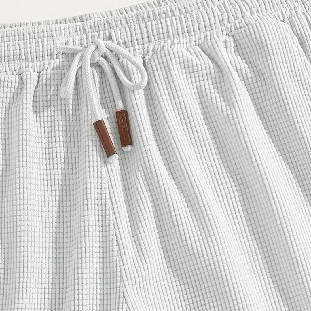 Dettaglio ravvicinato dei pantaloncini bianchi con coulisse annodata e puntali marroni