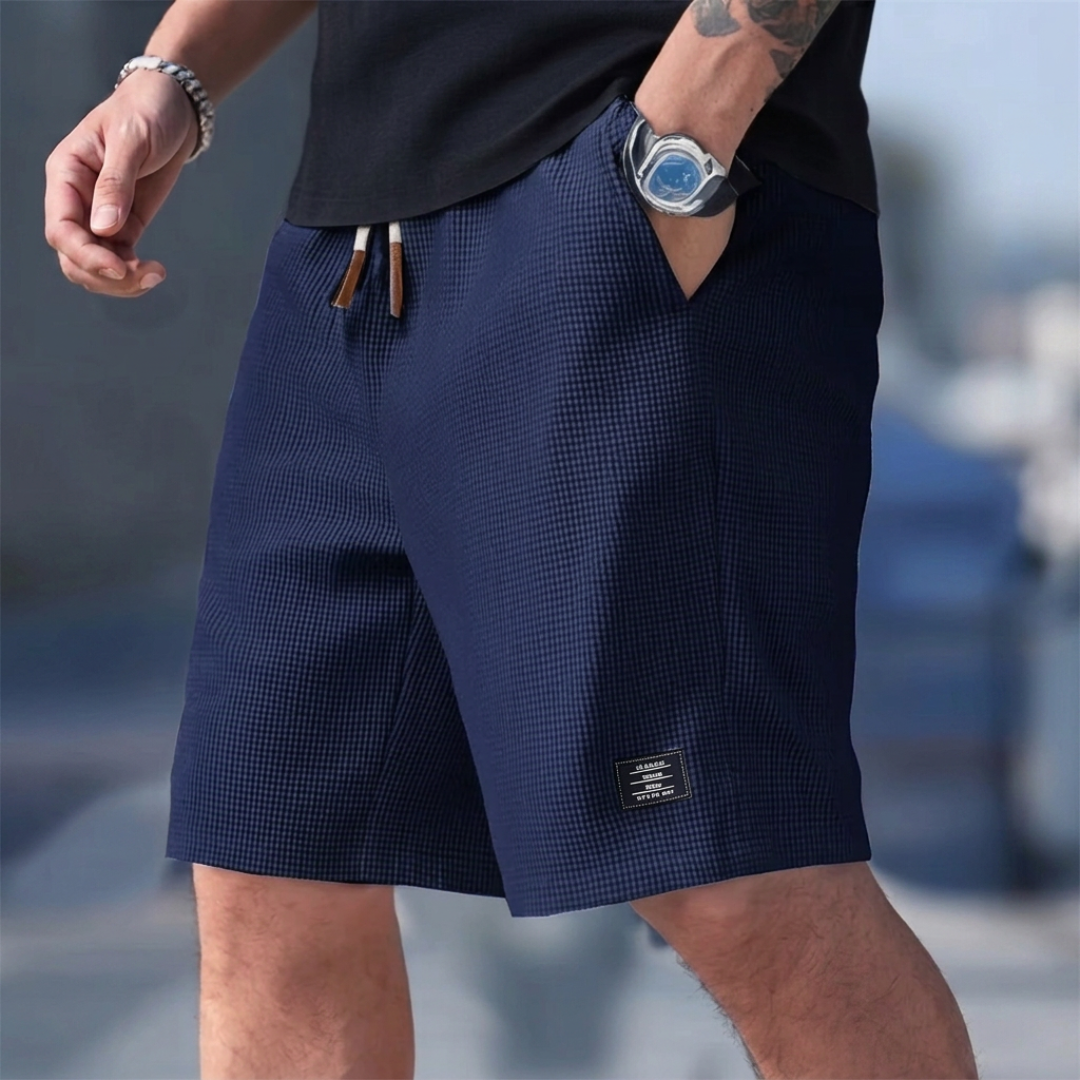 Pantaloncini uomo blu navy indossati con tasca laterale aperta e vita elastica