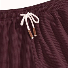 Dettaglio vita dei pantaloncini bordeaux con coulisse chiara e puntali in tono marrone