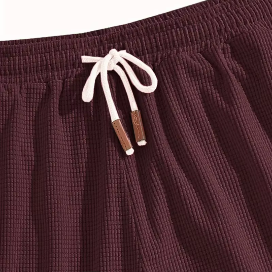 Dettaglio vita dei pantaloncini bordeaux con coulisse chiara e puntali in tono marrone