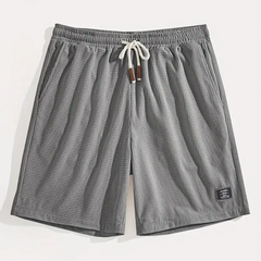 Pantaloncini grigi visti frontalmente con vita elastica arricciata e laccetto chiaro
