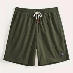 Pantaloncini verde militare distesi con laccio chiaro annodato ed etichetta sul lato