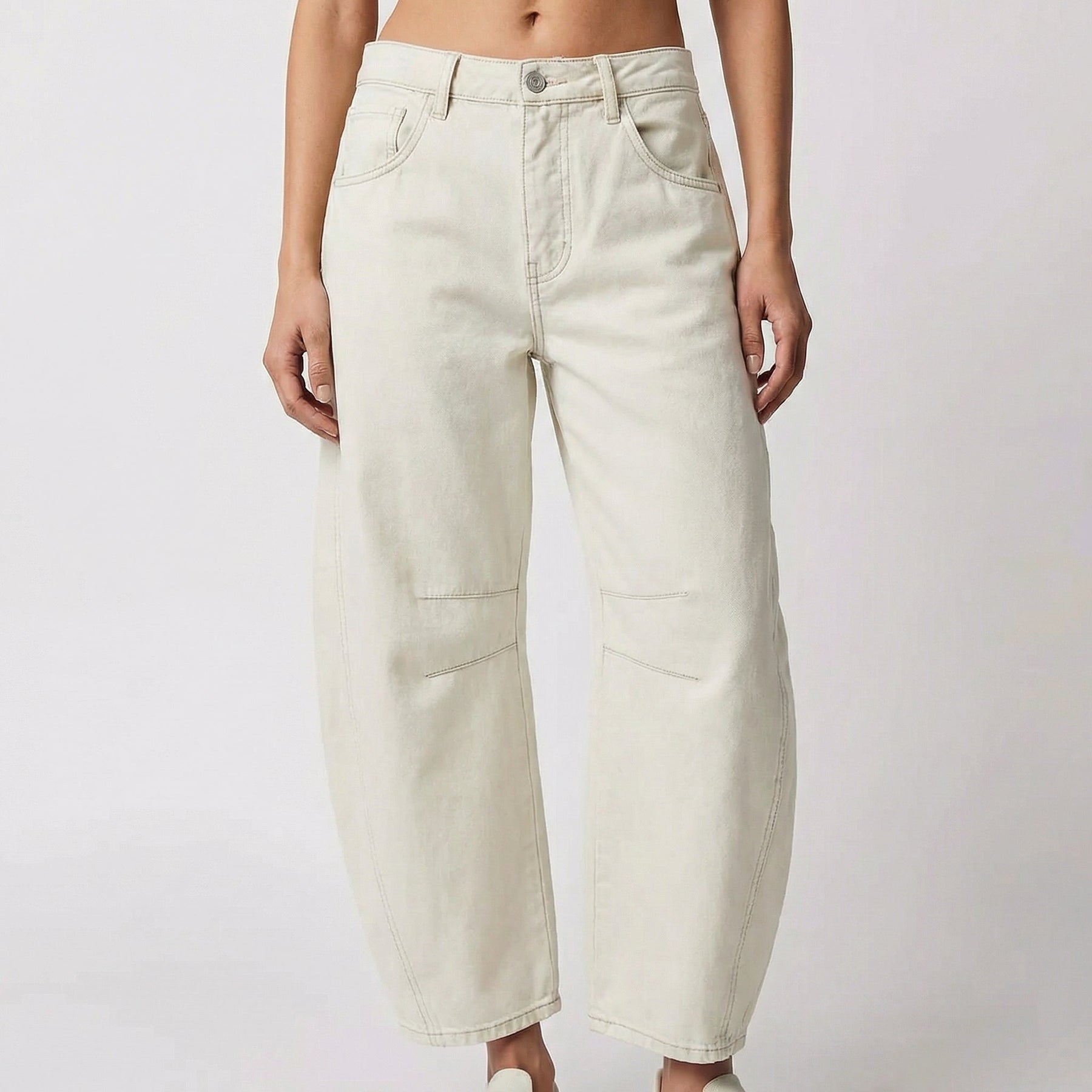 Pantaloni donna bianco panna con gamba curva, cuciture tono su tono e tasche frontali